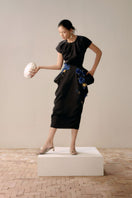 Black full-blown A-line midi skirt by Lecia, showcasing a flowing silhouette and smooth fabric on a neutral background.