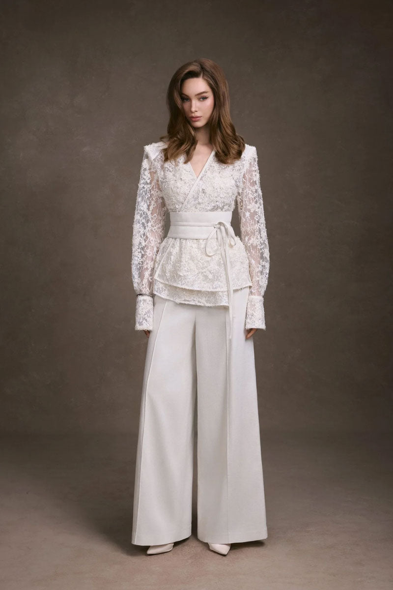 Keira Tong lace wrap top showing intricate lace details and long sleeves, styled for a chic, elegant look.