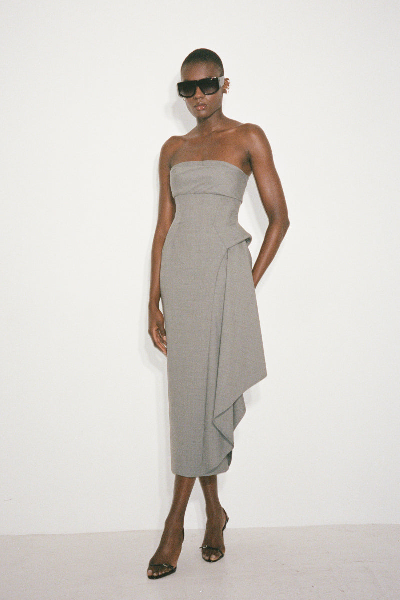 Nué Dylan midi dress displayed on a model, featuring a stylish, flowing design perfect for casual or semi-formal occasions.