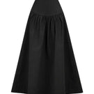 Black Ginevra maxi skirt by ANA + MARIA, flowing fabric and high waist design, shown on a model in a casual setting.
