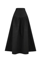 Black Ginevra maxi skirt by ANA + MARIA, flowing fabric and high waist design, shown on a model in a casual setting.