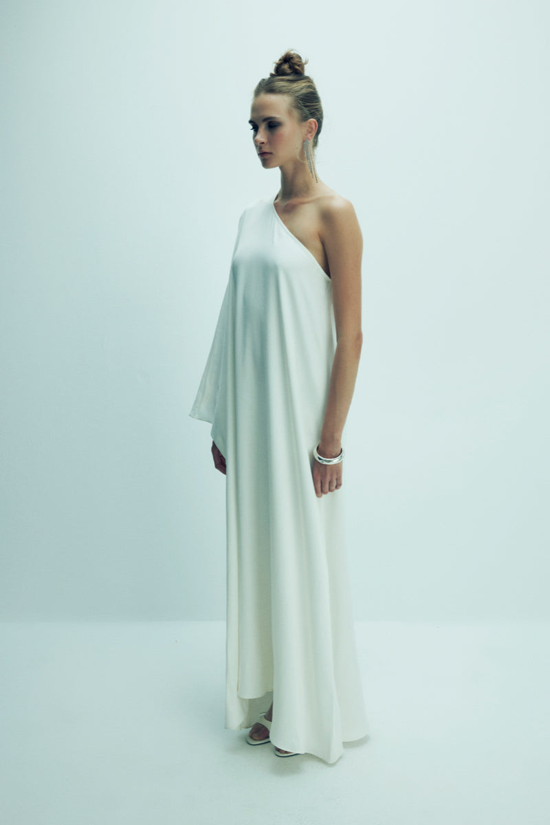 Nazlı Ceren Venus one-shoulder white maxi dress displayed on a model, flowing fabric and elegant design perfect for formal occasions.