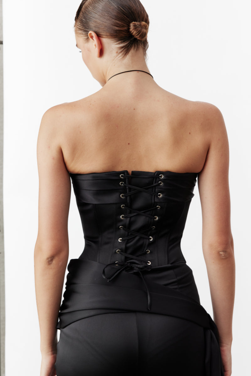 Black satin Bridget corset top by Nazlı Ceren featuring lace-up front and structured fit, styled on a mannequin.