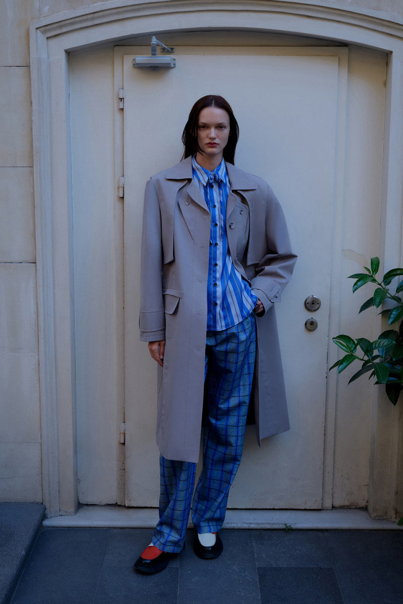 Gray ColoReve trench coat, stylish waterproof jacket with classic design, featuring a belt and tailored fit, displayed on a hanger.