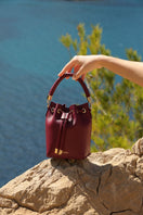 Saonara berry bucket top handle bag with rounded shape, leather strap, and top handle for casual and stylish wear.