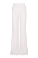 White organic linen flared pants by JC Pajares, showing a flowy, wide-leg design with a comfortable fit.