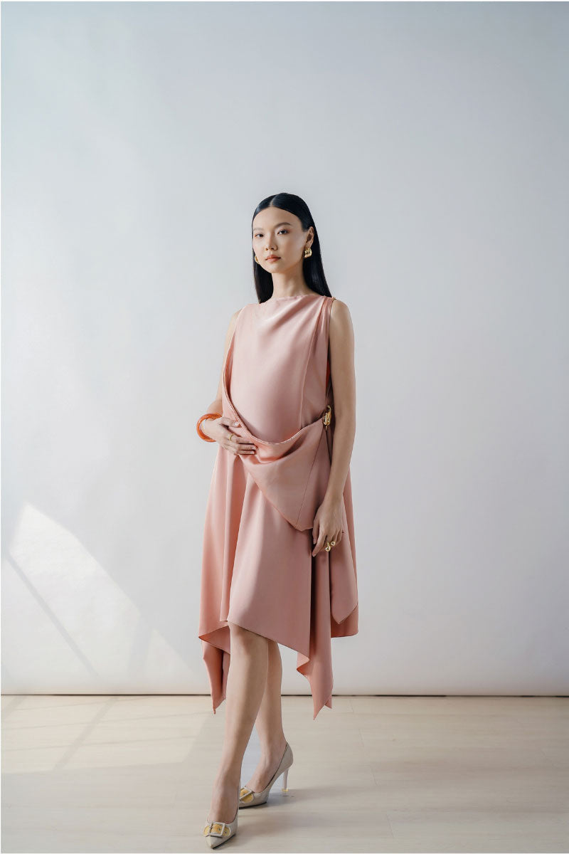 Rose pink draped asymmetric sleeveless midi dress by DOC BAN, showcasing elegant fabric and stylish asymmetrical design.