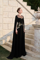 Black velvet satin cape sleeve gown by Tracy Studio, featuring elegant flowy fabric and sophisticated design.