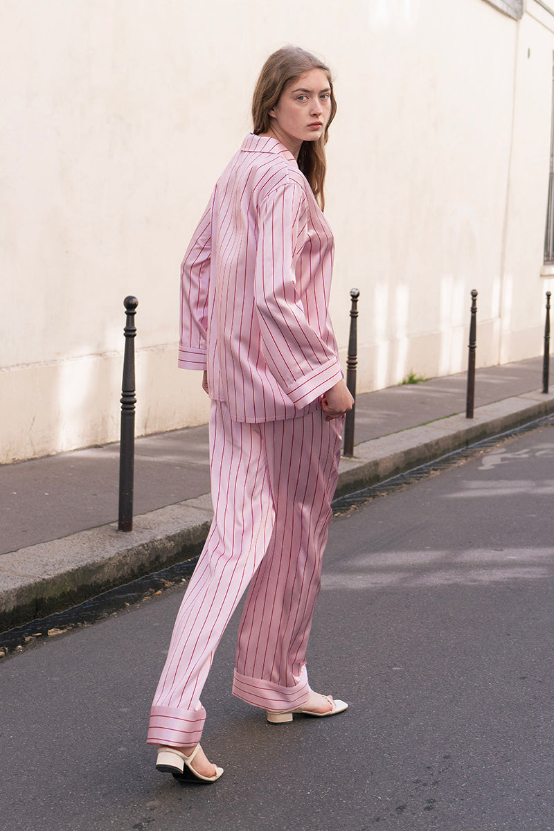 Pink striped silk pajama set from Not Just Pajama's Museum of Crush collection, featuring a long sleeve top and matching pants.