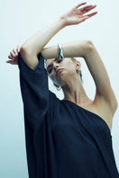 Black satin one-shoulder maxi dress by Nazlı Ceren, featuring elegant draping and a flowing silhouette.