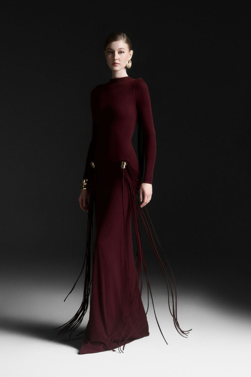 Red Maison Des Copains Avielle draped floor-length maxi dress displayed on a hanger with flowing fabric and elegant design.