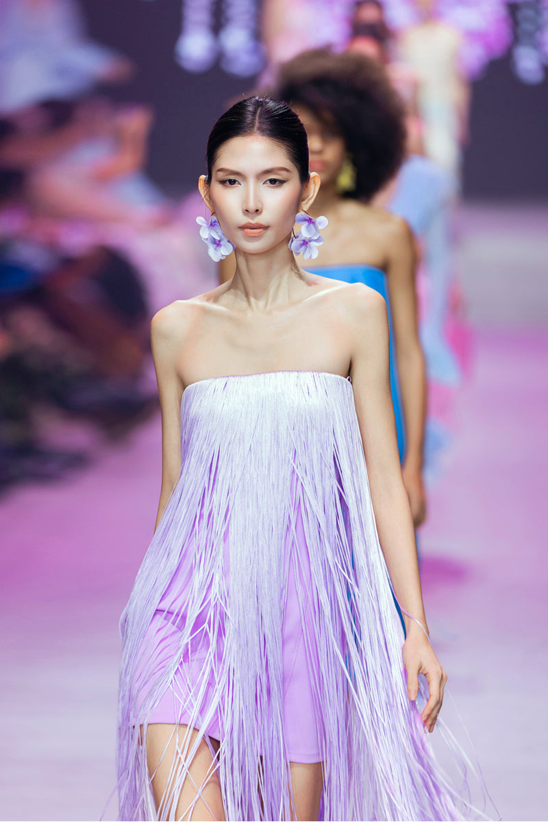 Valenciani lilac all-over fringe midi dress displayed on a hanger, showcasing its flowy fabric and intricate fringe details.