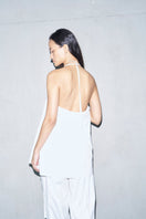 White Helmut top by URA, stylish sleeveless blouse with a relaxed fit and round neckline, shown on a model.