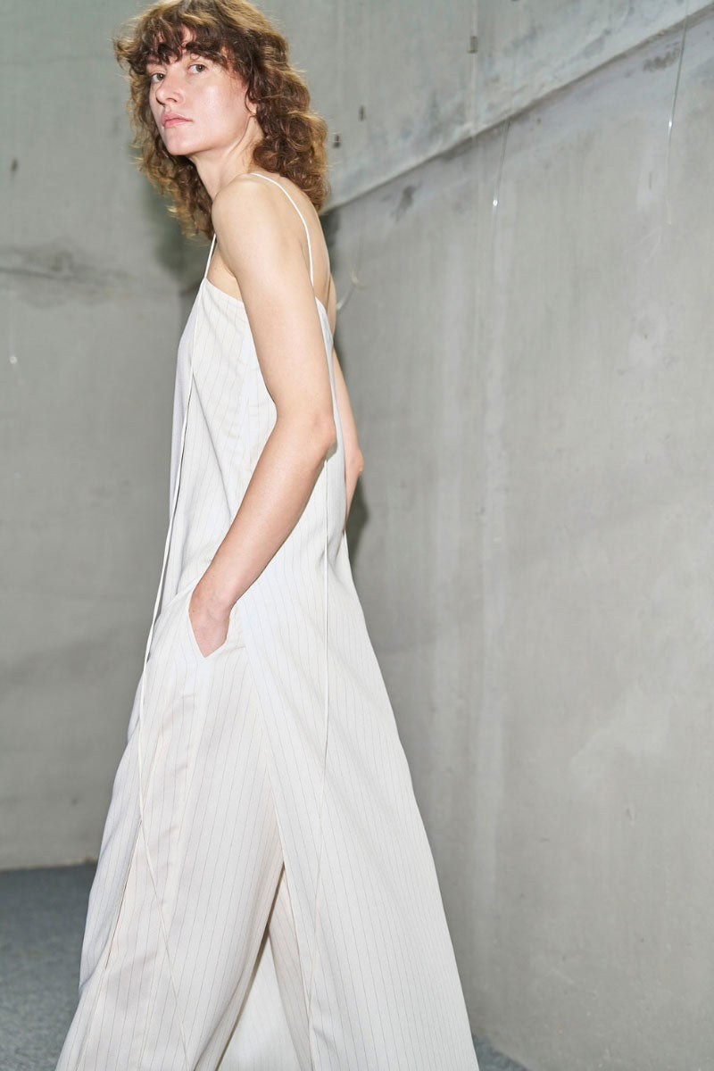Off-white Laura tunic top by URA, featuring a relaxed fit with flowing fabric and stylish neckline, displayed on a hanger.
