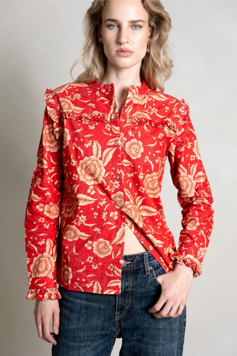 Raishma Esme red shirt displayed on a hanger, showcasing the stylish design and vibrant color of the women's shirt.