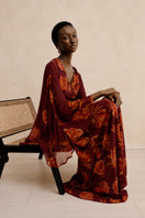 Red Raishma Karina maxi dress shown on a model, featuring a flowing silhouette and elegant design for formal occasions.
