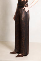 Raishma Jemma chocolate-colored pants with tailored fit, featuring a high waist and sleek design, displayed on a model.