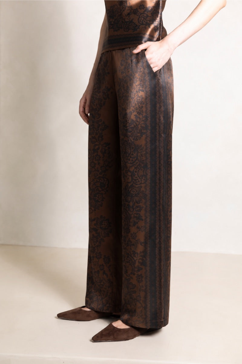 Raishma Jemma chocolate-colored pants with tailored fit, featuring a high waist and sleek design, displayed on a model.