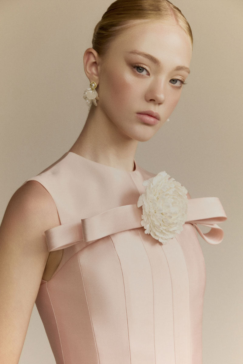White Plan Magnolia gown featuring elegant flowing fabric and delicate floral details, perfect for formal occasions.