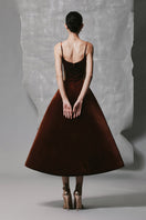 Brown velvet A-line midi dress with gold-banded detail from Phan Huy, showcasing its elegant flow and luxurious fabric.