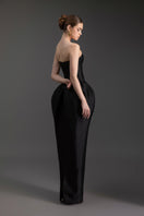 Elegant Le Thanh Hoa sculpted strapless gown with fitted bodice and flowing skirt, showcased on a mannequin.