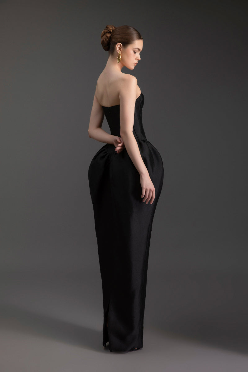 Elegant Le Thanh Hoa sculpted strapless gown with fitted bodice and flowing skirt, showcased on a mannequin.
