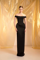Black off-shoulder gown by Le Thanh Hoa, featuring elegant design and flowing fabric, perfect for formal occasions.