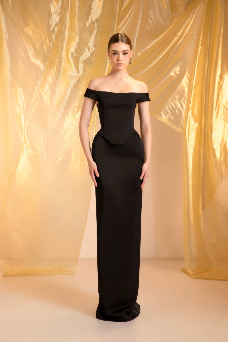 Black off-shoulder gown by Le Thanh Hoa, featuring elegant design and flowing fabric, perfect for formal occasions.