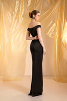 Elegant black off-shoulder gown by Le Thanh Hoa, featuring a flowing silhouette and stylish neckline for formal occasions.