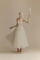 White Plan Anderson gown with elegant design, featuring flowing fabric and intricate details, perfect for formal occasions.