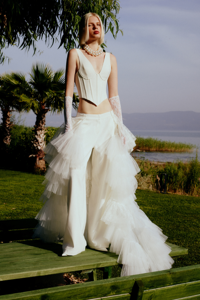 White crepe pants with ruffled train from Sudi Etuz, featuring a stylish, flowing design and tailored fit.