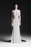 White Xantheir Mermaid gown by Maison Des Copains with a floor-length design, featuring elegant flowing fabric and a fitted silhouette.