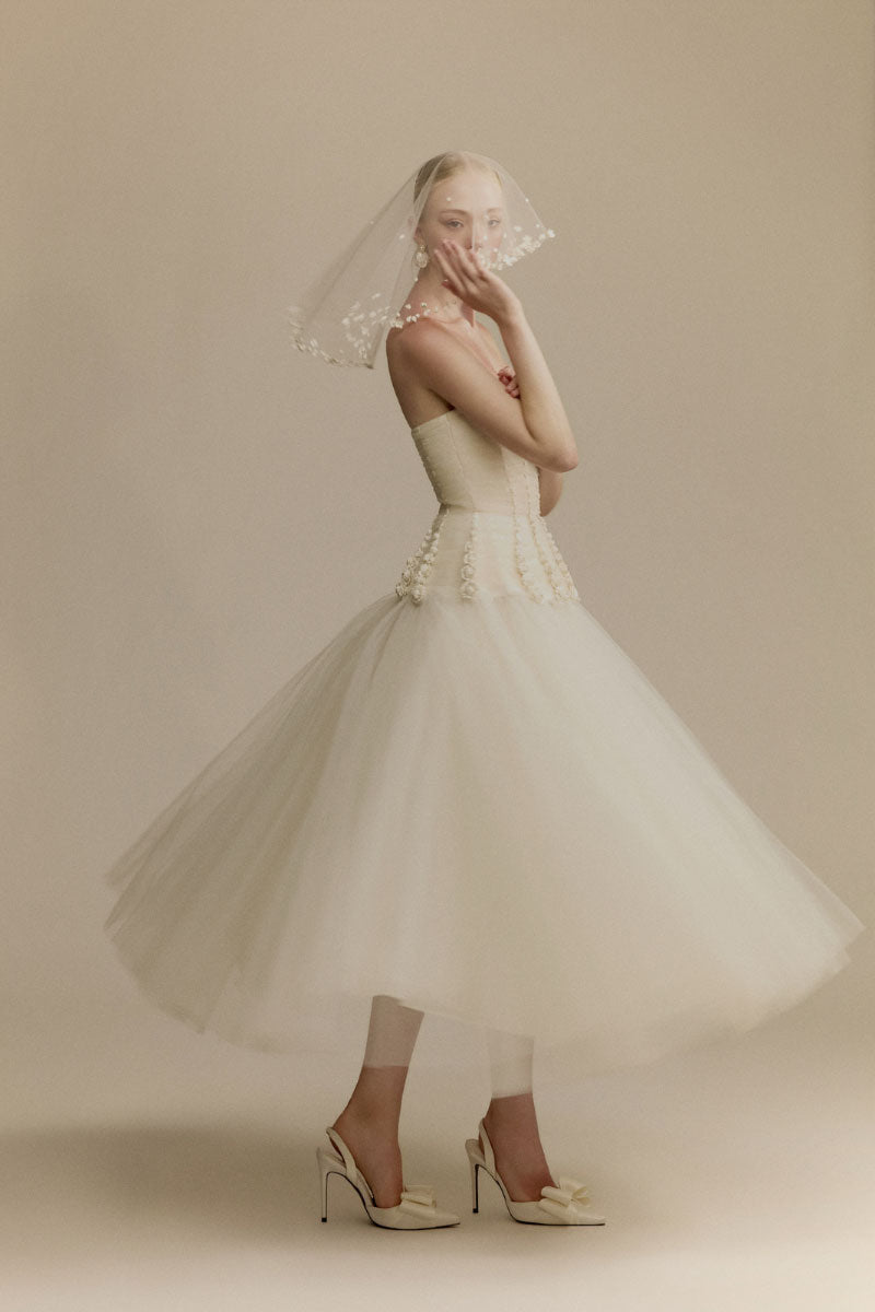 White Plan Anderson gown with elegant flowing fabric and intricate detailing, perfect for formal occasions.