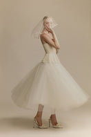 White Plan Anderson gown with elegant flowing fabric and intricate detailing, perfect for formal occasions.