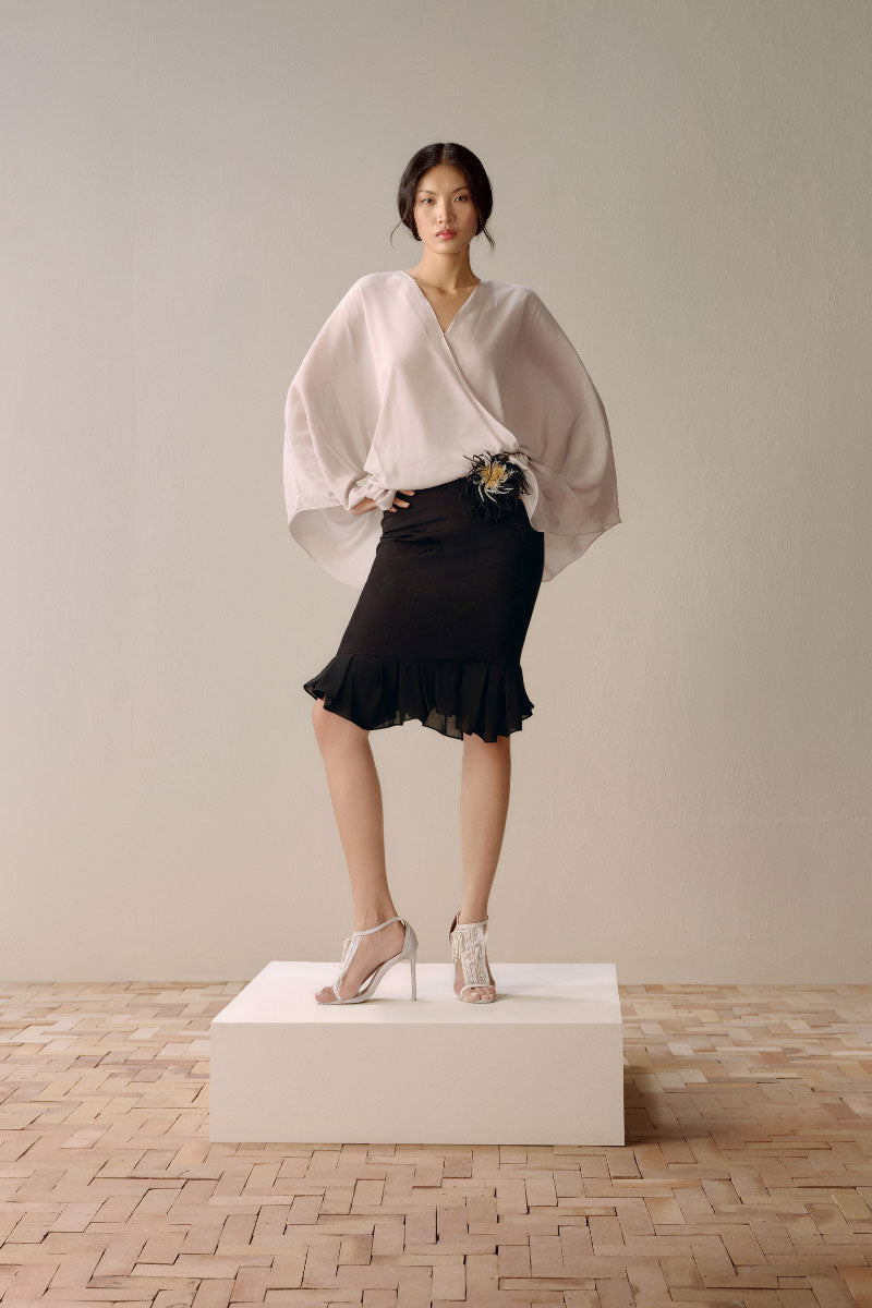 Black Leicia trumpet skirt in midi length, showcasing its fitted waist and flared hem, perfect for stylish everyday wear.
