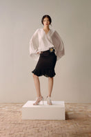 Black Leicia trumpet skirt in midi length, showcasing its fitted waist and flared hem, perfect for stylish everyday wear.