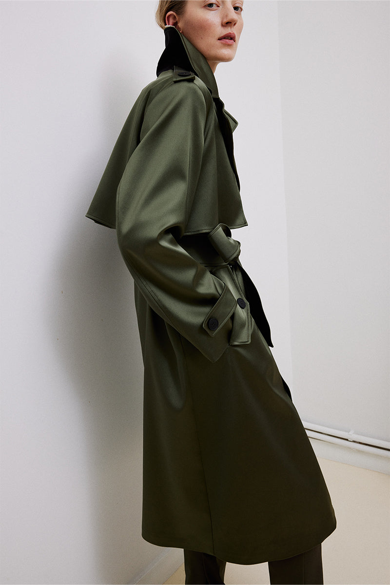 Green belted trench coat by TAGG, featuring a classic design with a waist belt, double-breasted front, and stylish tailored fit.