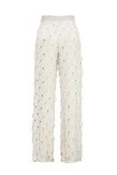 White beaded pants by Onalaja featuring intricate beadwork and a relaxed fit, displayed on a model.