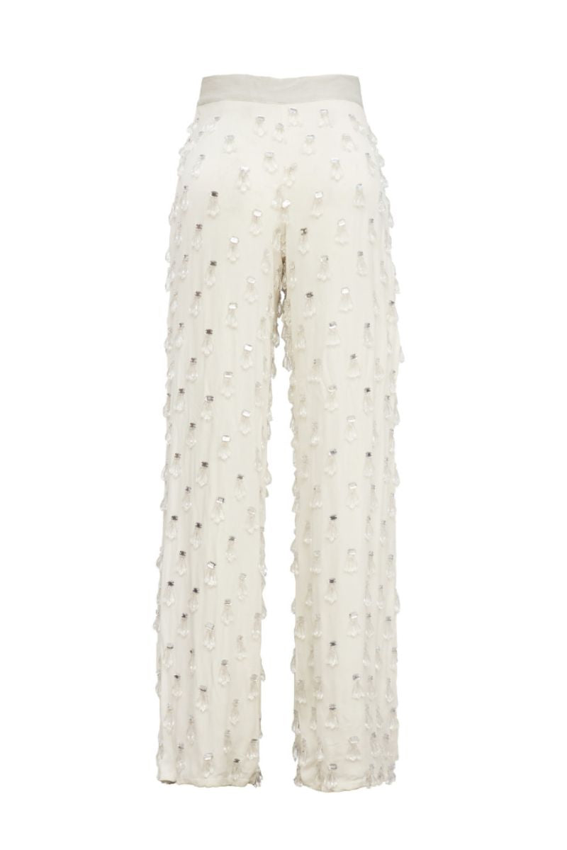 White beaded pants by Onalaja featuring intricate beadwork and a relaxed fit, displayed on a model.