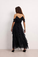 Overthesea West Coast Black maxi dress displayed on a hanger, featuring a flowing silhouette and elegant design.