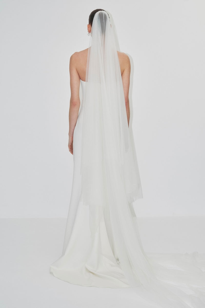 Long bridal veil with delicate lace edging, designed for wedding hair accessories by JC Pajares, flowing down the back.