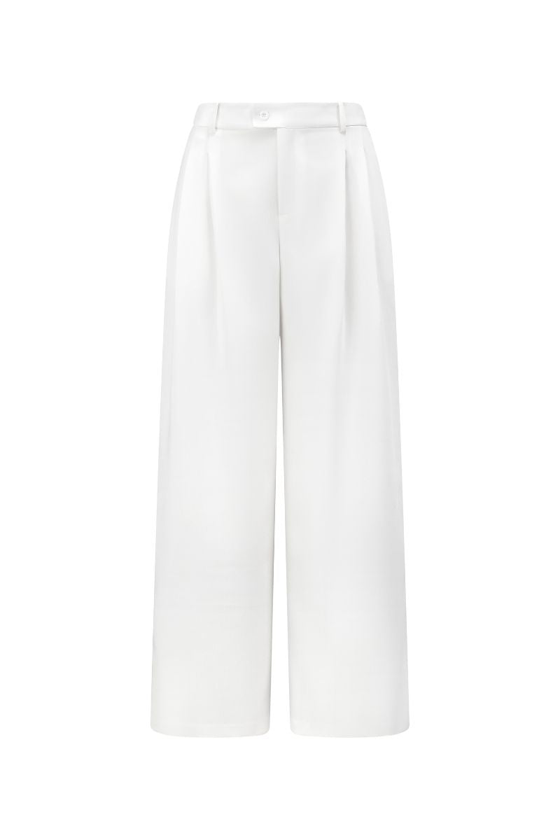 White JEMMIA pants by Arti Apparel, featuring a relaxed fit with pockets and stylish design, shown on a model.