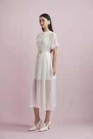 White Plan Alina Sheer Midi Dress displayed on a hanger, showcasing its lightweight, flowy fabric and elegant design.