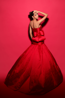 Elegant Cameron red bow trumpet gown by Tarık Ediz featuring a fitted silhouette and bow detail at the waist.