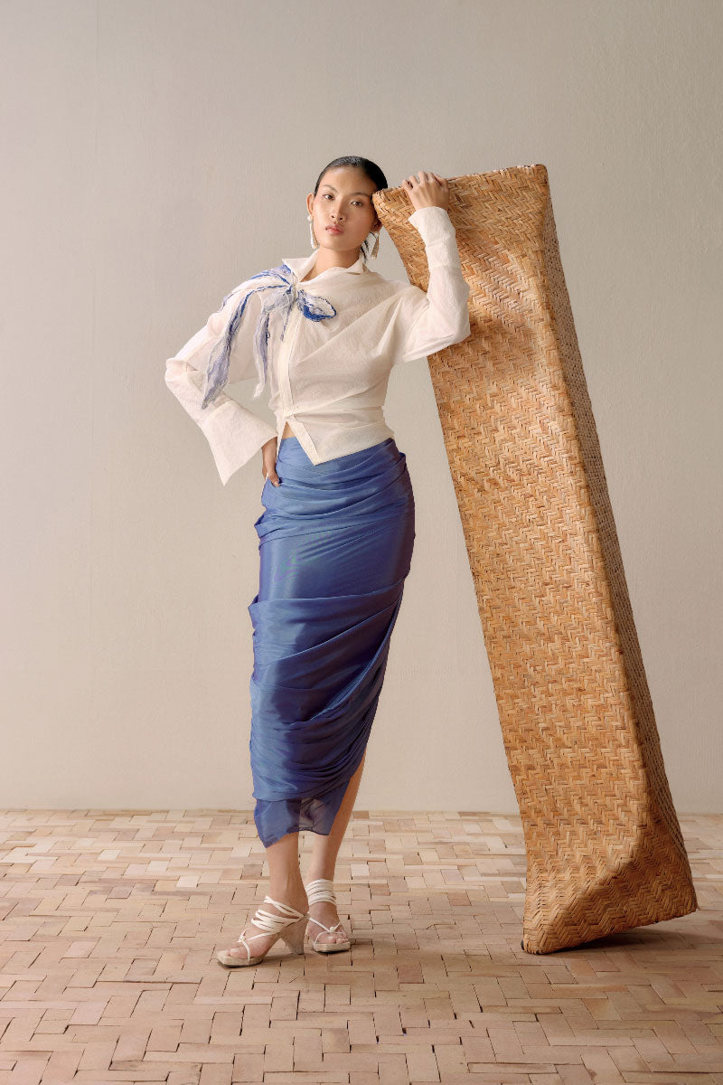 Shiny lumin blue draped midi skirt by LECIA featuring a sleek, flowing design and elegant draping for a stylish look.