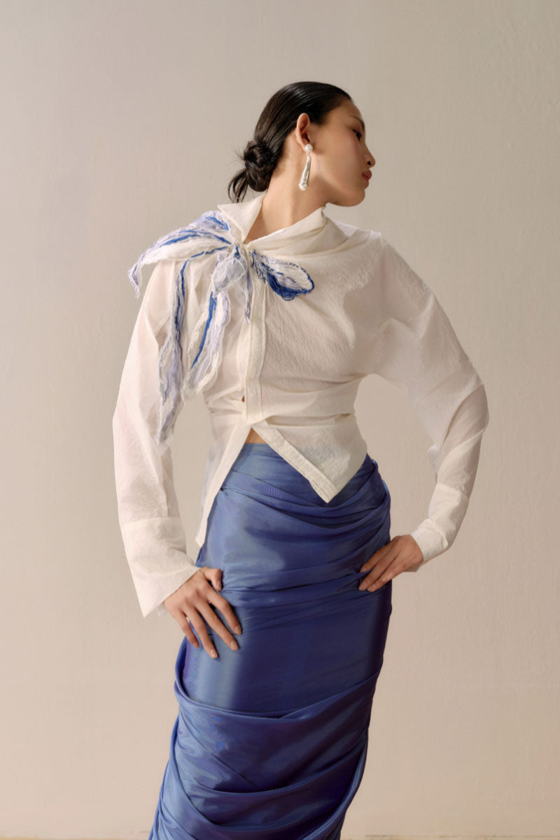 Shiny blue draped midi skirt by Lecia featuring a flowing, elegant design and metallic sheen.