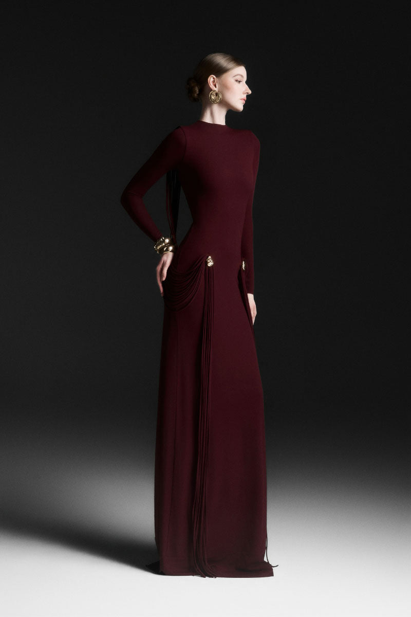 Red Maison Des Copains Avielle draped floor-length maxi dress displayed on a model showcasing elegant, flowing fabric and stylish design.