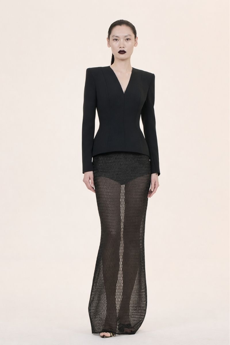 Nihan Peker Bobo long sleeve gown with flowing fabric and elegant design, displayed on a mannequin in a neutral setting.