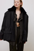 Gray oversized short trench coat by TAGG, shown on a hanger with visible collar and button details.