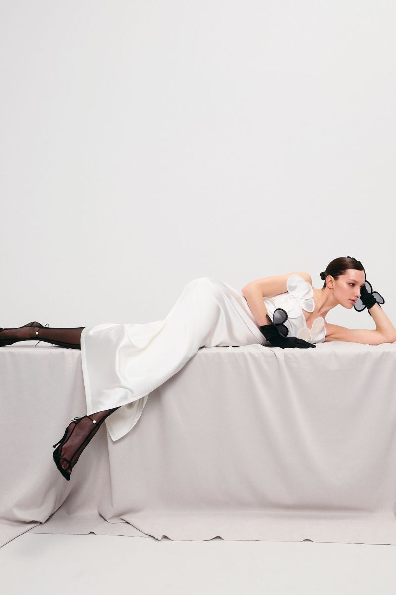 Ivory long-silhouette floral appliqué sheath maxi dress by Malva Florea displayed on a model.